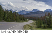 Highway with mountains in the background, Icefields Parkway, Jasper, Alberta, Canada. Стоковое фото, агентство Ingram Publishing / Фотобанк Лори
