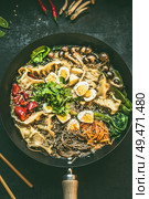 Close up of wok pan with vegetarian  korean hot pot and chopsticks on dark rustic kitchen table background, top view. Copy space. Asian food concept. Стоковое фото, агентство Ingram Publishing / Фотобанк Лори
