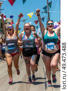 A group of women in athletic attire sprinting down a city street, showcasing speed and determination. Стоковое AI-изображение, AI-художник Данила Большаков / Фотобанк Лори