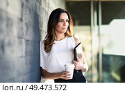 Middle-aged businesswoman taking a coffee break in an office building. Young woman with california highlights in her hair.. Middle-aged businesswoman taking a coffee break in an office building. Стоковое фото, агентство Ingram Publishing / Фотобанк Лори