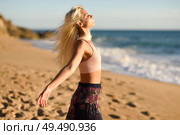 Woman enjoying the sunset on a beautiful beach in Cadiz, Andalusia, Spain. Young female opening arms and breathing the sea air.. Woman enjoying the sunset on a beautiful beach. Стоковое фото, агентство Ingram Publishing / Фотобанк Лори