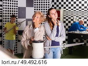 Girl and grandmother in quest room with friends, trying to find solution of conundrum. Стоковое фото, фотограф Яков Филимонов / Фотобанк Лори