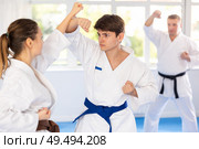 Woman and man in kimono sparring together in sport gym during karate training. Стоковое фото, фотограф Яков Филимонов / Фотобанк Лори