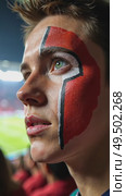 A close-up of a fan's face painted with intricate colors team designs, their eyes wide with anticipation as they watch the match on a giant sport stadium. Стоковое AI-видео, аниматор Sergey Grishin / Фотобанк Лори
