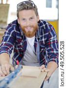 male worker sanded piece of wood in the studio. Стоковое фото, агентство Ingram Publishing / Фотобанк Лори