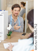patient with arm in sling at hospital reception desk. Стоковое фото, агентство Ingram Publishing / Фотобанк Лори