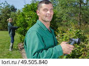 man watering plants with hose. Стоковое фото, агентство Ingram Publishing / Фотобанк Лори