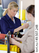 female trainer inspecting information from the tablet. Стоковое фото, агентство Ingram Publishing / Фотобанк Лори