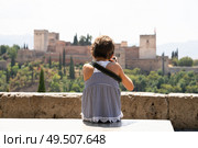 Little girl making photo with DSLR camera to the Alhambra from San Nicolas viewpoint in Albacin, Granada.. Little girl making photo with DSLR camera to the Alhambra. Стоковое фото, агентство Ingram Publishing / Фотобанк Лори
