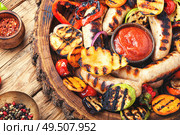 Grilled sausages and vegetables with sauce ketchup on a wooden table.Autumn food. Grilled sausages with vegetables. Стоковое фото, агентство Ingram Publishing / Фотобанк Лори