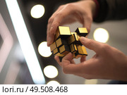 man collects the cube rubik. Intellectual puzzle. Редакционное фото, агентство Ingram Publishing / Фотобанк Лори