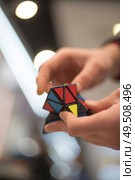 man collects the cube rubik. Intellectual puzzle. Редакционное фото, агентство Ingram Publishing / Фотобанк Лори