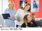 female hairdressing apprentice showing client the cut. Стоковое фото, агентство Ingram Publishing / Фотобанк Лори