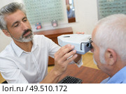 senior patient while sitting with optician in clinic. Стоковое фото, агентство Ingram Publishing / Фотобанк Лори