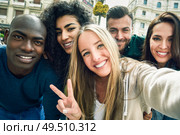 Multiracial group of friends taking selfie in a urban street with a blonde woman in foreground. Three young women and two men wearing casual clothes.. Multiracial group of young people taking selfie. Стоковое фото, агентство Ingram Publishing / Фотобанк Лори