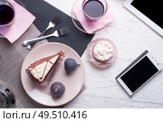 life style set at meeting in cafe.Thai blue, Butterfly pea tea served with fresh figs and panna cotta cake and fruit piece of cake on serving napkins. flat lay. Стоковое фото, агентство Ingram Publishing / Фотобанк Лори