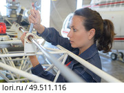 young female with wrench fixing part of jetliner. Стоковое фото, агентство Ingram Publishing / Фотобанк Лори