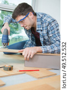 assembling furniture from chipboard using a cordless screwdriver. Стоковое фото, агентство Ingram Publishing / Фотобанк Лори