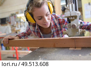 female carpenter cutting wood with an electrical jigsaw. Стоковое фото, агентство Ingram Publishing / Фотобанк Лори