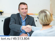 friendly smiling businesswoman and businessman handshaking in the office. Стоковое фото, агентство Ingram Publishing / Фотобанк Лори