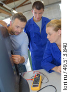 teacher and apprentices fixing a television. Стоковое фото, агентство Ingram Publishing / Фотобанк Лори