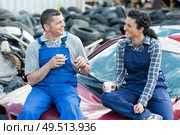 mechanics having coffee sat on scrap car. Стоковое фото, агентство Ingram Publishing / Фотобанк Лори