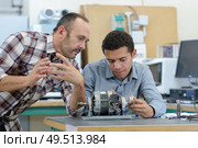 young attractive students of mechatronics working on project. Стоковое фото, агентство Ingram Publishing / Фотобанк Лори