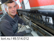 portrait of a man fixing a heavy machinery. Стоковое фото, агентство Ingram Publishing / Фотобанк Лори