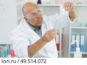 male scientist in the medical laboratory filling test tubes. Стоковое фото, агентство Ingram Publishing / Фотобанк Лори