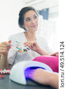 female manicurist showing choices for nail extension. Стоковое фото, агентство Ingram Publishing / Фотобанк Лори
