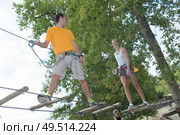 visitors in adventure park clambering with ropes. Стоковое фото, агентство Ingram Publishing / Фотобанк Лори