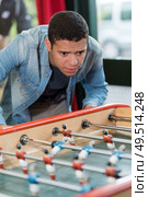 focused picture of young man playing babyfoot. Стоковое фото, агентство Ingram Publishing / Фотобанк Лори