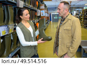 Sales assistant showing wellingtons to customer. Стоковое фото, агентство Ingram Publishing / Фотобанк Лори