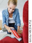 cheerful blonde young woman hoovering chair. Стоковое фото, агентство Ingram Publishing / Фотобанк Лори