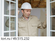 a window fitter checking installation. Стоковое фото, агентство Ingram Publishing / Фотобанк Лори
