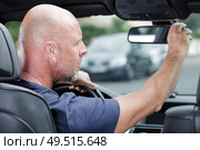 mature man adjusting the rear view mirror in car. Стоковое фото, агентство Ingram Publishing / Фотобанк Лори