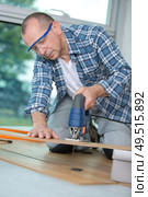 carpenter cutting laminated planks for layered parquet using bandsaw. Стоковое фото, агентство Ingram Publishing / Фотобанк Лори
