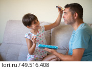 Little cute daughter doing make-up to her father. Dad spending free time with her daughter. Alternative masculinity concept.. Little cute daughter doing make-up to her father. Стоковое фото, агентство Ingram Publishing / Фотобанк Лори