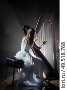 girl playing the harp on stage during a concert. Стоковое фото, агентство Ingram Publishing / Фотобанк Лори