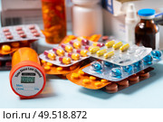 Pile of colorful medical pills in blisters and bottles on blue background. Drug and antibiotics prescription for treatment medication.. Pile of pills. Стоковое фото, агентство Ingram Publishing / Фотобанк Лори