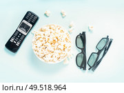bowl of popcorn, nd remote control for TV and 3d glasses over blue background, movie and cinema concept. popcorn and 3d glasses. Стоковое фото, агентство Ingram Publishing / Фотобанк Лори