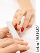 Professional processing of nails by a nail file, isolated. Стоковое фото, агентство Ingram Publishing / Фотобанк Лори