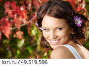 Portrait of young flirting woman against red leaves in a summer garden. Стоковое фото, агентство Ingram Publishing / Фотобанк Лори