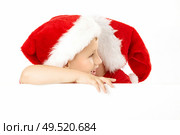 One little boy in a cap of santa whispers another something over the blank banner, isolated. Стоковое фото, агентство Ingram Publishing / Фотобанк Лори