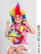 Funny beautiful party little girl in disguise with wig in many colors and pink round sunglasses. Funny little girl in disguise with wig and sunglasses. Стоковое фото, агентство Ingram Publishing / Фотобанк Лори