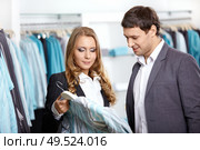 Young man and the woman consider a shirt in shop. Стоковое фото, агентство Ingram Publishing / Фотобанк Лори