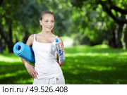 Young girl with a bottle of water and gymnastic mat. Стоковое фото, агентство Ingram Publishing / Фотобанк Лори