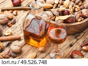 Shot glass with aromatic alcohol from nuts.Nut liquor.Tincture on nuts.. Autumn nutty liquor. Стоковое фото, агентство Ingram Publishing / Фотобанк Лори