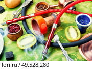 Arabic smoking hookah with taste of kiwi.Fruit shisha tobacco. Tobacco with taste of kiwi.Oriental tobacco hooka. Oriental shisha with kiwi flavor. Стоковое фото, агентство Ingram Publishing / Фотобанк Лори