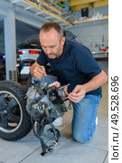 a biker polishing spare part. Стоковое фото, агентство Ingram Publishing / Фотобанк Лори